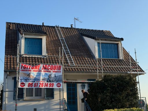 Maison avec fenêtres bleues, échelle sur le toit et un panneau sur la façade.